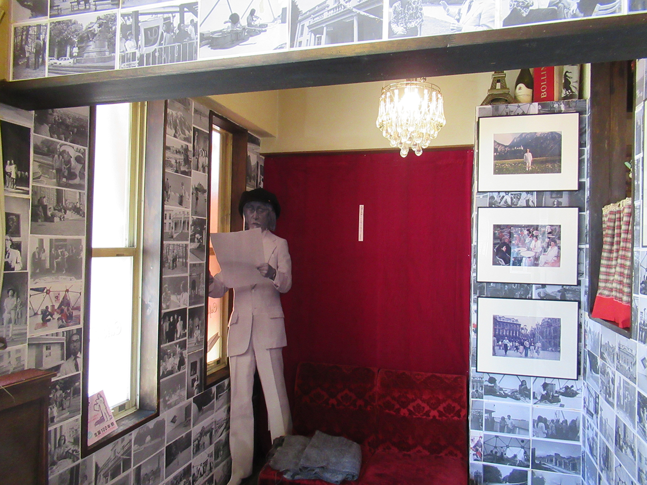 松澤の等身大パネルと壁に貼られた欧州訪問時の写真（Café Tac）