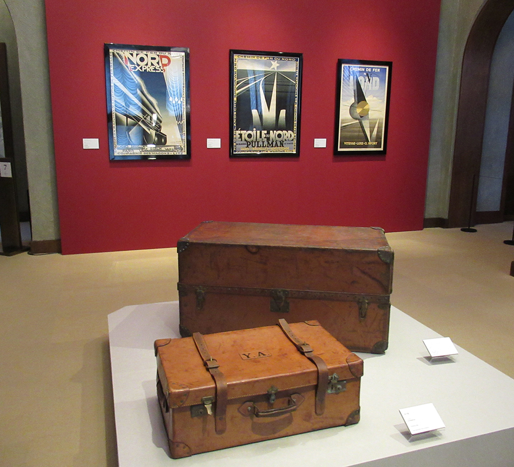 朝香宮家を創設した朝香宮鳩彦（やすひこ）王所用の「旅行鞄」（1920年代　東京都庭園美術館蔵）〈手前〉と「ルイ・ヴィトン　ワードローブ・トランク」（1920年代　個人蔵）。ポスターは左から、カッサンドル「ノール・エクスプレス」「エトワール・デュ・ノール」、「シュマン・ドゥ・フェール・デュ・ノール」